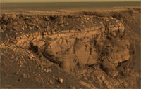 A view from Mars Exploration Rover Opportunity shows layered deposits in the wall of an impact crater. Studying layered deposits like these can help reveal the ancient history and climate of Mars.