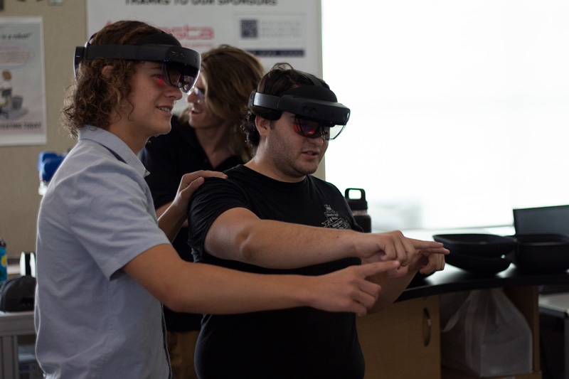 High school students using the Microsoft HoloLens to show NASA engineers the spacecrafts they designed.