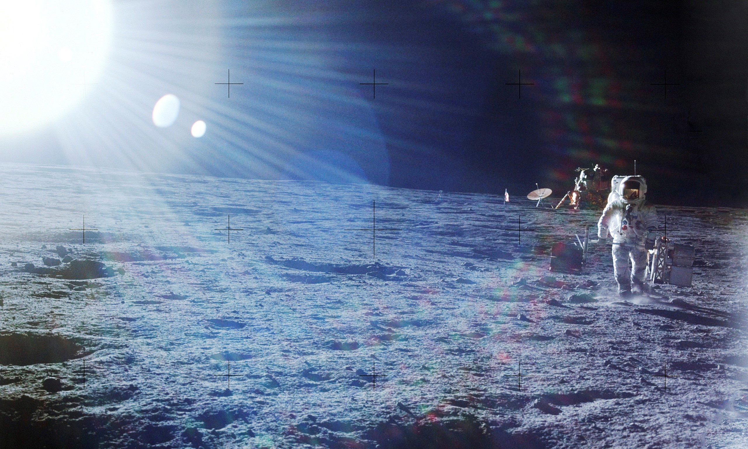 slide 3 - An astronaut is carrying equipment on the Moon. The image is light by a bright sunburst and lens flare that give it an unearthly feel.