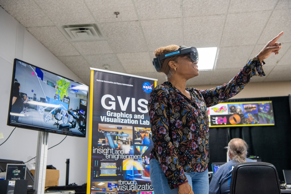 NASA engineer looks through the Microsoft HoloLens to see the spacecrafts the students designed.